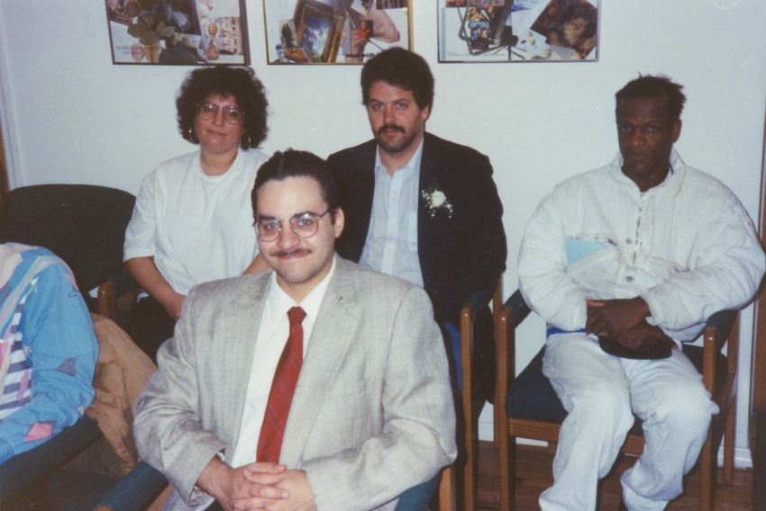 Download the full-sized image of A Photograph Featuring Marsha P. Johnson Sitting in a Chair Wearing a White Tracksuit