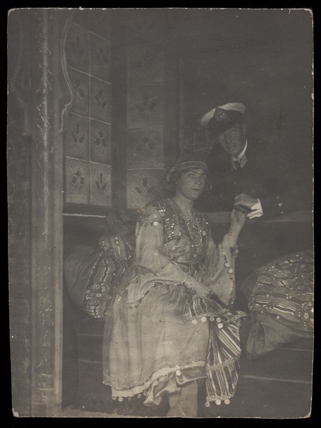 Download the full-sized image of Sailors posing as a couple, one in drag, as they embrace through a window. Photographic postcard, 191-.