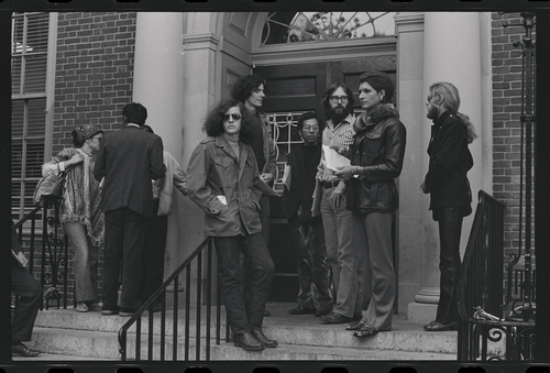 Download the full-sized image of Photograph of Sylvia Rivera and Protestors Holding Papers in Front of a Building Entrance